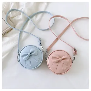 Close-up of sweet mini round crossbody bags with bow detail in pastel pink and blue
