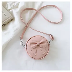 Detail of sweet pink round crossbody bag for girls featuring a 3D bow decoration