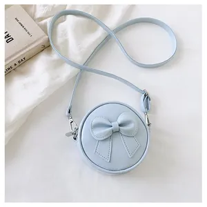 Detail view of light blue round crossbody bag with cute bow decoration for girls