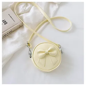 Detail view of a sweet yellow mini round crossbody bag for girls with a cute 3D bow.