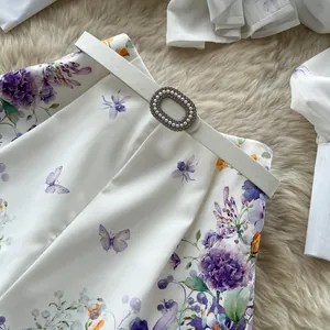 Close-up detail of high-waist floral print shorts with elegant pearl buckle belt