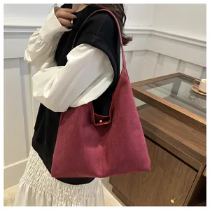 Dettaglio di una borsa tote grande in pelle scamosciata bordeaux stile vintage
