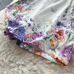 Close-up detail of floral print high waist shorts with butterfly pattern and fine stitching.