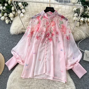 Detailed macro view of romantic pink floral blouse with stand collar and lantern sleeves