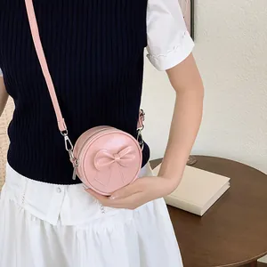 Sweet pink round crossbody bag for girls featuring a large decorative bow detail.