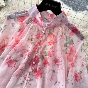 Detail of elegant pink floral print blouse featuring stand collar and lantern sleeves