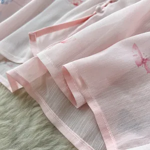Macro detail of pink butterfly print fabric showing high-quality stitching and soft texture
