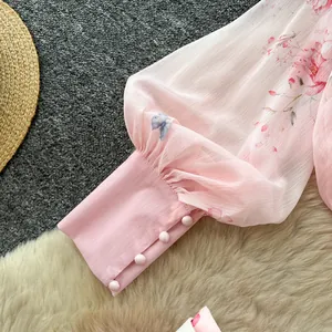 Close-up detail of pink floral print lantern sleeve with elegant four-buttoned cuff design
