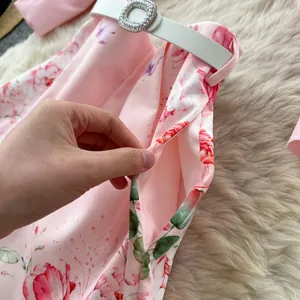Detail view of pink floral shorts with side pocket and rhinestone belt buckle