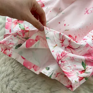 Close-up detail showing the elegant floral print hem and fine stitching on pink shorts