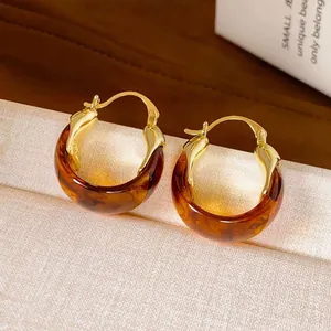 Elegant vintage amber brown resin hoop earrings with polished gold-toned metal accents