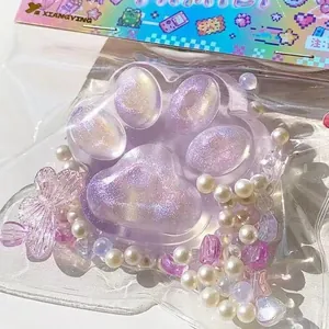 Nahaufnahme eines lilafarbenen Glitzer-Katzenpfoten-Squishy-Spielzeugs in Folie