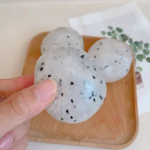 Close-up detail of a pitaya patterned rice ball squishy toy being squeezed for stress relief.