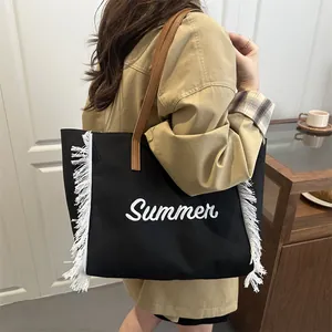 Sac cabas élégant en toile noire avec des détails de franges blanches et broderies été