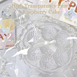 Nahaufnahme des transparenten Himbeerkuchen-Squishy-Spielzeugs mit Perlen und Schleife