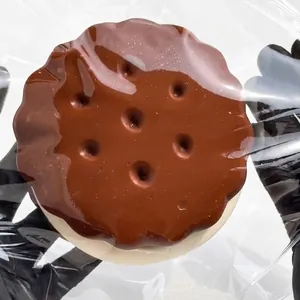 Detailed view of a realistic chocolate sandwich biscuit squishy toy in clear packaging.