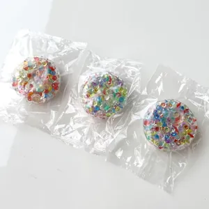 Macro detail of three colorful beads fidget squeeze balls in individual clear packaging bags