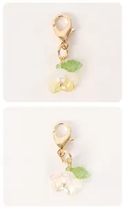 Detailed view of a delicate white flower charm with a green leaf for DIY accessories