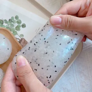 Close-up of translucent sticky rice squishy toy being stretched for stress relief