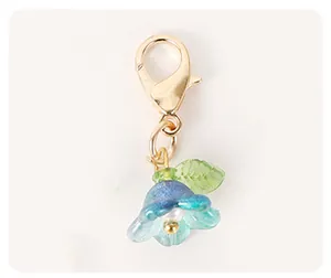 Macro detail of an elegant blue flower pendant accessory with a golden lobster clasp