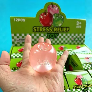 Juguete antiestrés manzana rosa transparente, presentado en caja de venta de 12 piezas.
