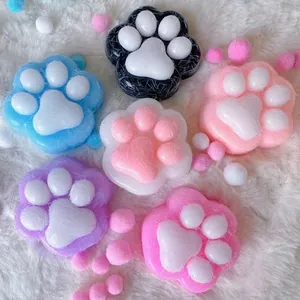 Bunte Katzenpfoten-Squishys zum Stressabbau auf einem weißen flauschigen Hintergrund