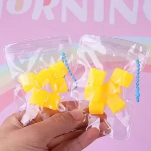 Close-up detail of mango-shaped squeeze toys in transparent mini bags with blue beaded chains