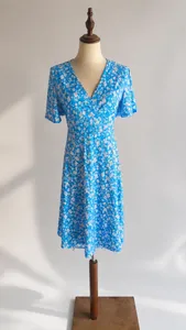 Blaues Kleid mit Blumenmuster und V-Ausschnitt auf einer professionellen Schneiderpuppe
