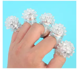 Detalle de cinco anillos de gelatina blanda con LED parpadeantes en una mano humana
