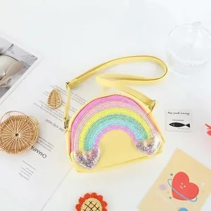 Primer plano de un mini bolso de hombro para niños con arcoíris y corazones de brillo.