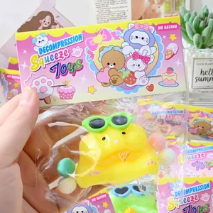 Close-up view of a cute yellow hamster squeeze toy with sunglasses in retail packaging