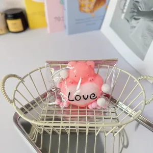 Detailed macro view of a pink heart bear squeeze toy with Love text in clear packaging