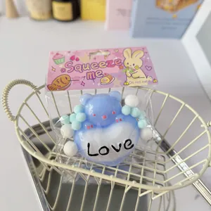 Detailed close-up of a cute blue heart bear squeeze toy in its retail packaging