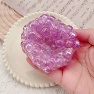 Macro detail of a purple pearlescent bubble stress relief squishy toy being held