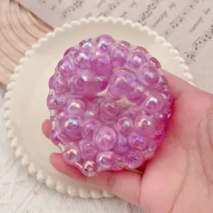 Detailed view of translucent purple exploding bead squeeze toy with bubble texture in hand