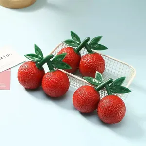 Detail of six orange fruit-shaped squeeze toys in a white wire basket for stress relief