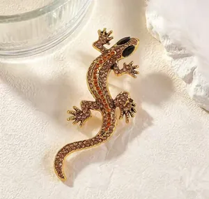 Detailed close-up of a vintage-style gold lizard brooch set with sparkling rhinestones.