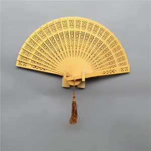 Macro view showing the intricate hollow carved patterns on a wooden folding fan