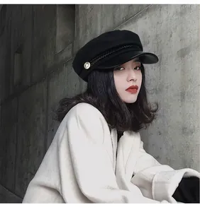 Close-up of stylish black octagonal cap with leather brim worn by a female model outdoors