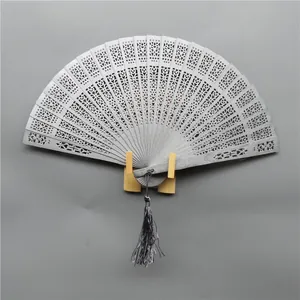 Detailed view of an elegant grey hollow carved wooden folding fan with decorative tassel