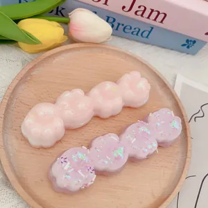 Macro detailoverzicht van glitter roze en paarse pootvormige knijpspeeltjes op dienblad