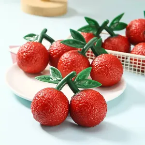 Detailed close-up of realistic red bayberry squishy stress relief toys on a white plate