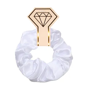 White satin scrunchie hair tie with diamond-shaped packaging card for women's hair.