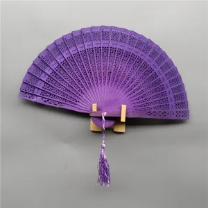 Elegant purple sandalwood folding fan featuring intricate hollow patterns and silk tassel