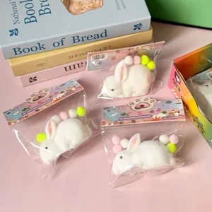 Trois jouets squishy lapin blanc emballés avec des pompons colorés pour déstresser