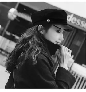 Side view of a vintage black newsboy cap with a leather brim on a female model