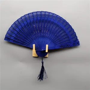 Detailed view of an elegant navy blue hollow sandalwood folding fan with a silk tassel