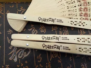Detailed close-up of hollowed-out wooden folding fans with intricate cutout patterns