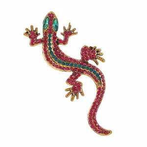Vintage gold-tone lizard brooch featuring sparkling pink and teal rhinestones