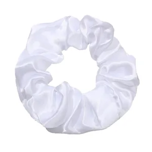 Detail view of a white satin scrunchie featuring a smooth and glossy silk-like texture.